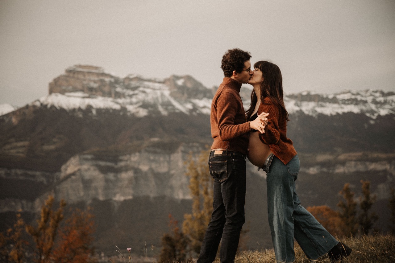 Grossesse femme enceinte montagne automne couple qui s'embrasse