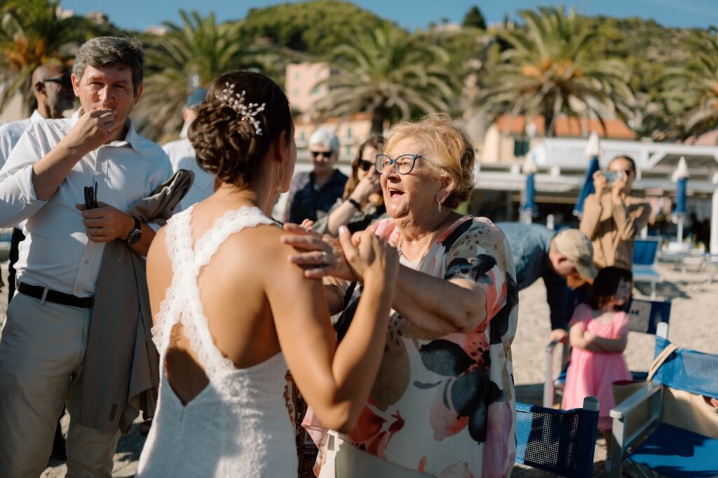 Bride meeting Italian grandmother after ceremony, Liguria beach wedding