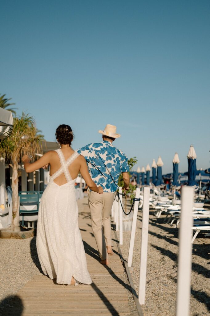 Newlyweds walking along the beach, wedding photography Italian Riviera
