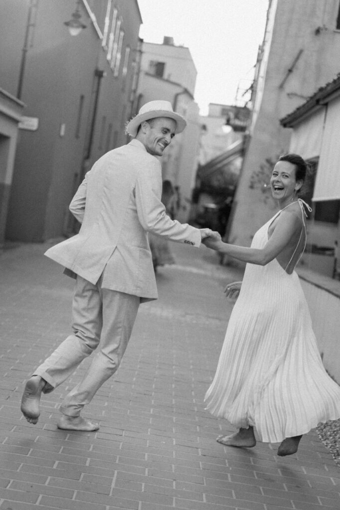 Couple dancing barefoot in Italian alley, documentary wedding photography Liguria